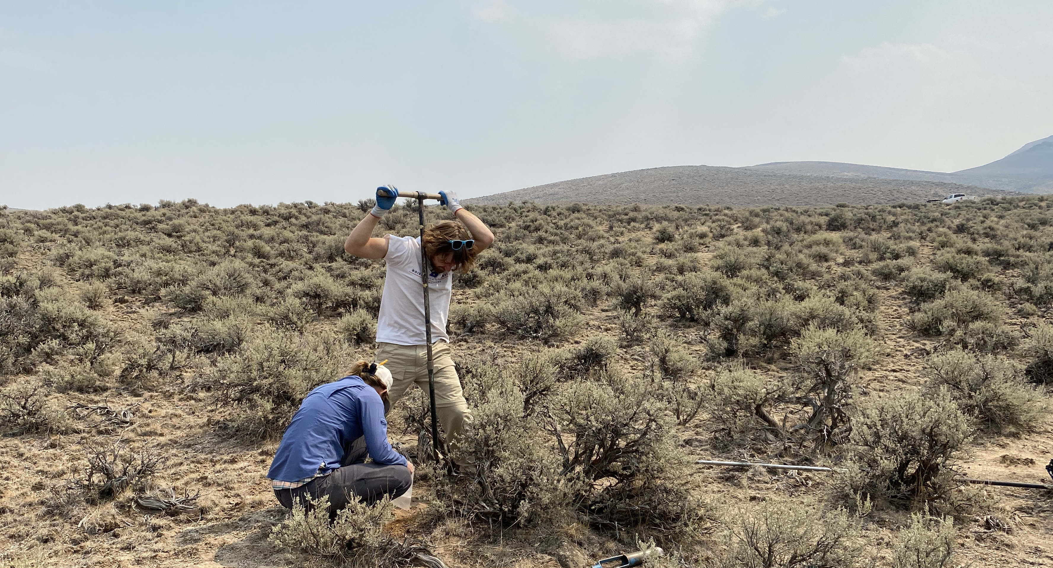 BSU undergraduate Kyle operating the soil auger and Julia trying to keep up with sample labeling  